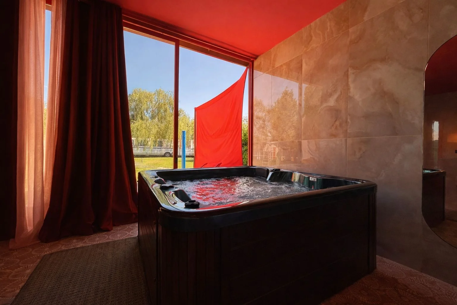 Jacuzzi privado de la Suite Tokyo Red con decoración en rojo carmín, escapada romántica cerca de Madrid en heart & ponie Chinchón